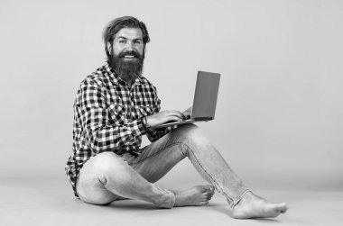 Defteri olan özenli bir adam. Kareli tişörtlü sakallı adam internette ders dinliyor. Webinar ve iş eğitimi. Laptop kullanarak. Online öğrenme kavramı. Sosyal uzaklık