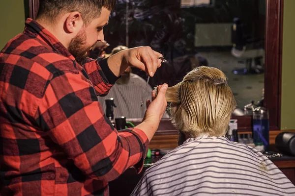 Rinfrescante effetto. maestro barbiere fa l'acconciatura e lo styling con asciugatrice. Concetto barbiere. Un hipster con la barba che si taglia i capelli in un barbiere. Lavoro di parrucchiere professionale. Stile di vita — Foto Stock