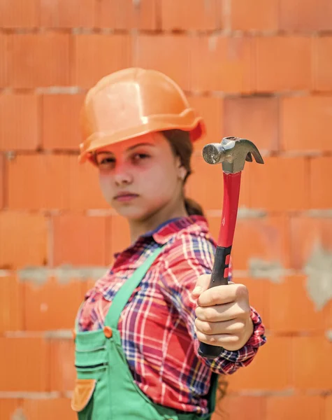 Adolescente chica constructor en protector casco uso martillo, herramienta de construcción — Foto de Stock