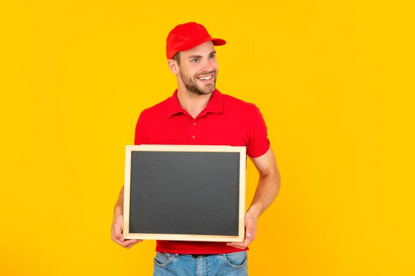 Happy guy with bristle holding chalkboard with copy space on yellow background, advertisement — Stock fotografie