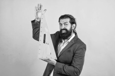 Okul öğretmeni geometri dersinde geometrik üçgenle gülümsüyor.