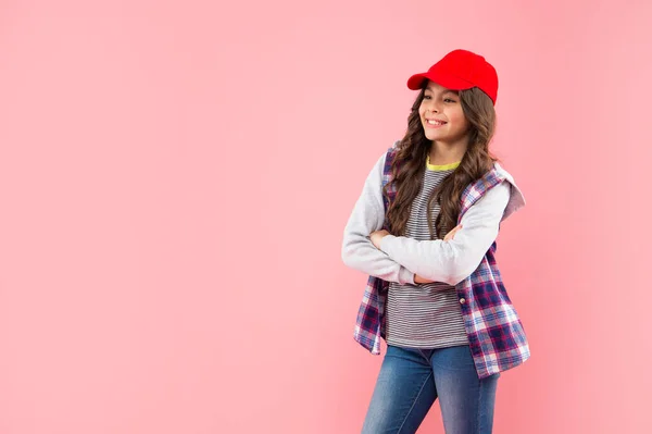 Smiling kid with curly hair in cap. teen hipster beauty hairstyle. female casual fashion model. — Stockfoto