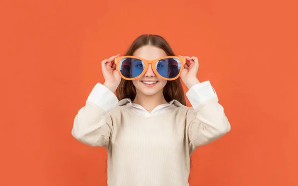 Happy kid in party glasses on orange background, fun —  Fotos de Stock