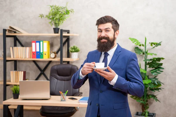 Cheerful mature entrepreneur in jacket having coffee break at office, business — kuvapankkivalokuva