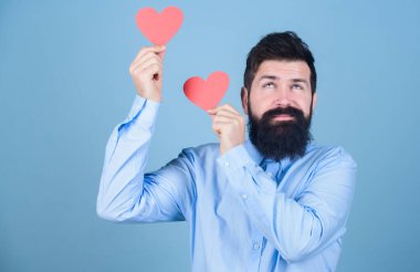 Çekici sakallı ve bıyıklı adam romantik bir modda. Sevgiyi hissetmek. Çıkma ve ilişki kavramı. Aşkta mutlu. İnsanın sevildiğini hissetmesini sağlamak. Sevgililer günü kartı olan sakallı bir hippi. Aşkı kutla.