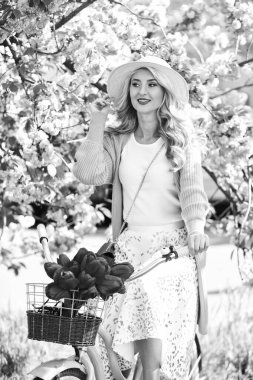 Al çiçeğini. Retro motorlu çiçek satıcısı kız. Parkta hoş bir yürüyüş için klasik bir bisiklet. Moda kadını bahar doğasını sever. Bahar çiçekli Japon sakurası ağacı. Kirazlı güzellik. Çiçekçi