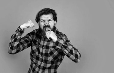 Müzik konsepti. Bıyıklı vahşi yakışıklı adam. Olgun şarkıcı şarkı söyler. Erkeklik ve karizma. Karaoke kulübünde eğleniyorum. Mikrofonlu sakallı hippi şarkıcı