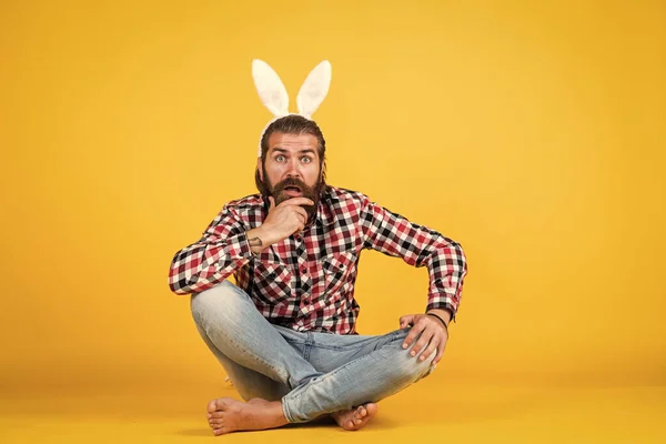 Наближається Великдень... щасливе Великдень. смішний бородатий чоловік носить вуха кролика. хлопець у костюмі кролика розважається. святкування весняних свят. полювання на яйце. Жорстокий щасливий чоловік на жовтому тлі. смішний кролик — стокове фото