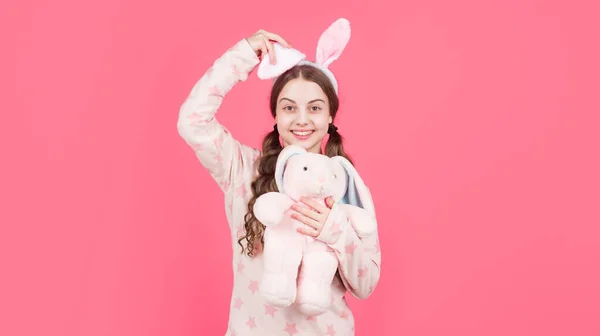 Plus mignon que n'importe quel lapin. enfant en oreilles de lapin et pyjama. C'est le moment de s'amuser. adorable enfant jouer avec jouet. — Photo