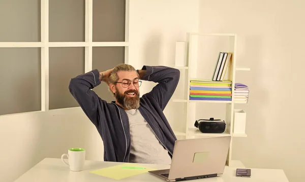 Çevrimiçi video konferansı. Hippi adam dizüstü bilgisayarını kullanarak saçlarını tıraşsız bırakmış. Bornozlu adam evde dinleniyor. Uzaktan kumanda. Çevrimiçi iletişim. İnternet işi. Yalnızlık insani etkileşimden yoksun. — Stok fotoğraf