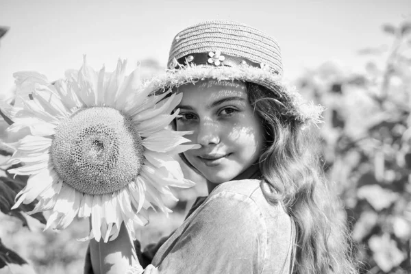 Όμορφο πρόσωπο κοριτσάκι παίζει ηλιοτρόπια φόντο φύση — Φωτογραφία Αρχείου