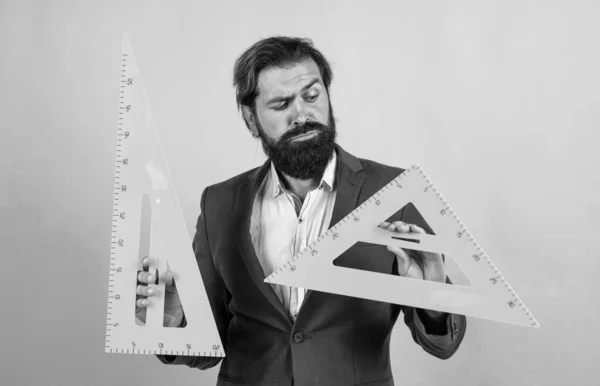 Hombre barbudo maduro en traje de negocios mantenga regla de triángulo matemático, gráficos —  Fotos de Stock