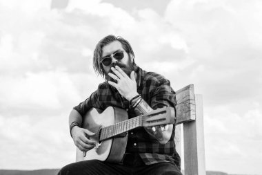 Sigara içiyorum. Müzik ve vokal konsepti. Akustik gitar çalan bir adam. Bıyıklı ve sakallı vahşi adam gitar tutuyor. Müzik dükkanı. Sakallı adam bir rock yıldızı. Sıradan bir erkek gitarist.