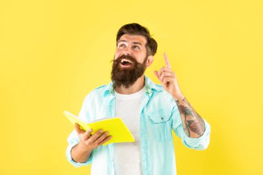 Hipster adamın sarı arka planda not defteri okumasından esinlenilmiştir.