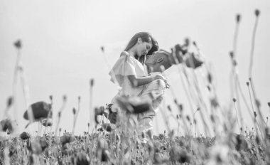 Duygularını ifade etmek. Kız ve erkek sahada. Gelin ve damat. Kırmızı gelincik çiçekli romantik çift. Aile yaz tatili. Mutlu bir adam ve aşık bir kadın bahar havasının tadını çıkarırlar. Mutlu ilişkiler