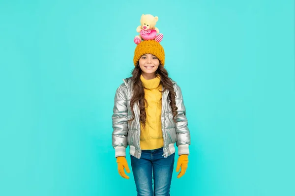 Šťastný kluk v nafoukané bundě a klobouku. dětství. teen dívka držet hračka medvěd. — Stock fotografie