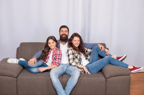 Батько мати і дитина на дивані. дружня сім'я обіймається. щасливі батьки з дитиною вдома — стокове фото