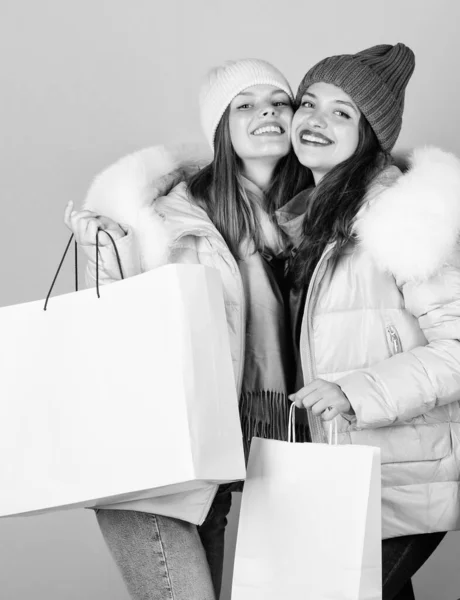 Kup zimowe ubrania. Dziewczyny noszą ciepłe kurtki. Koncepcja zakupów. Sprzedaż i zniżka. Kobiety kupują zimowe ubrania. Przewodnik po sklepach. Fałszywe futro. Torby na zakupy. Dobrze się razem bawimy. Czarny piątek — Zdjęcie stockowe