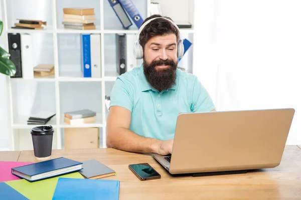 Empresário feliz em fones de ouvido digitando no laptop no escritório, comunicação on-line — Fotografia de Stock