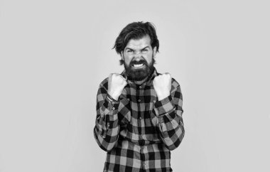 Yetişkin, yakışıklı bir adam sarı arka planda dikilmiş çılgın ve çılgın başarısını kutluyor.