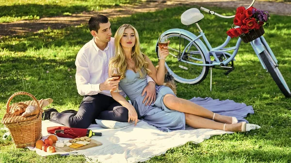 是时候放松了公园里浪漫的野餐。可爱的情侣在毛毯上约会。露营的概念。恋爱中的幸福夫妻。女人和男人一起躺在公园里享受这一天。情人节野餐 — 图库照片