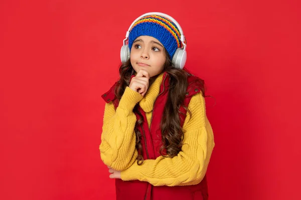 Vintermode. Tonårstjej i hatt och hörlurar. modernt liv i barndomen. — Stockfoto