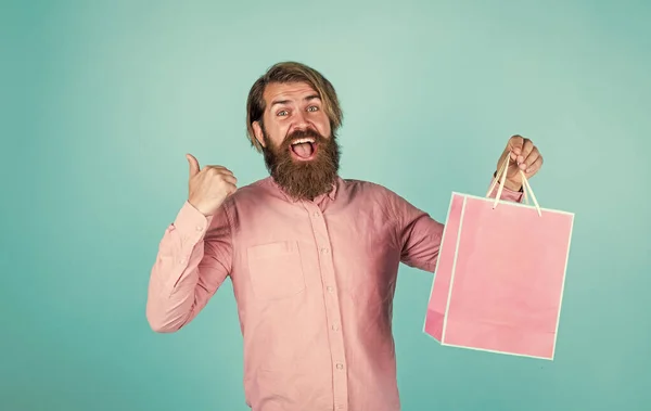 Mutlu sakallı adam elinde hediye paketi tutuyor. Mutlu yıllar veya yıldönümleri. Bayram kutlaması. Ona sürpriz yapacağım. Alışveriş ve satış. Olgun, vahşi hippi. Alışveriş merkezinde satın al — Stok fotoğraf