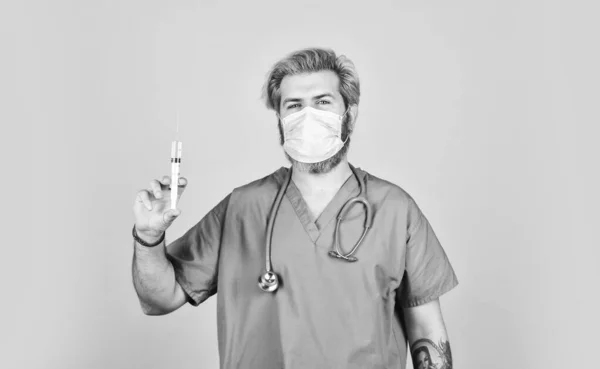 Ο υπεύθυνος υγείας καλεί το εμβόλιο σε σύριγγα. Γιατρός ή νοσοκόμος που χορηγεί εμβόλιο κατά του ιού. επιδημία του κορωνοϊού από την Κίνα. ώριμος γιατρός χρησιμοποιεί σύριγγα στη μάσκα αναπνοής. ειδικευμένη νοσοκόμα κάνει ένεση — Φωτογραφία Αρχείου
