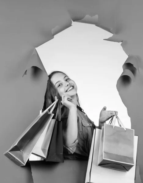 Fröhliches Kind mit Einkaufstaschen. Niedliche Kindereinkäuferin. Teenager Mädchen shopaholic. — Stockfoto