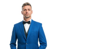 Papyonlu, mavi takım elbiseli olgun bir adam. Büyük patron resmi giyiniyor..