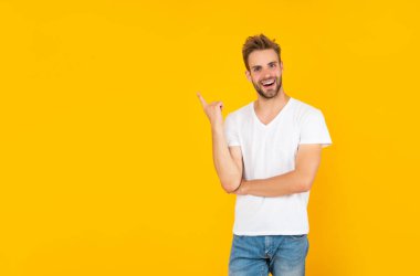 Sarı arka planda sakallı genç bir adam. saç ve sakal bakımı.