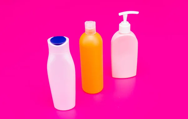 Ideal para os seus produtos de higiene pessoal. garrafas de plástico fundo rosa. Frascos de produtos de higiene pessoal multicoloridos. PEAD — Fotografia de Stock