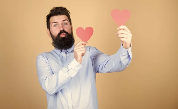 Dos corazones latiendo como uno. Hombre barbudo sosteniendo corazones rojos. Hipster con corazones pequeños. Sexy hombre de San Valentín con tarjetas en forma de corazón. Feliz día de San Valentín. Celebración romántica del amor —  Fotos de Stock