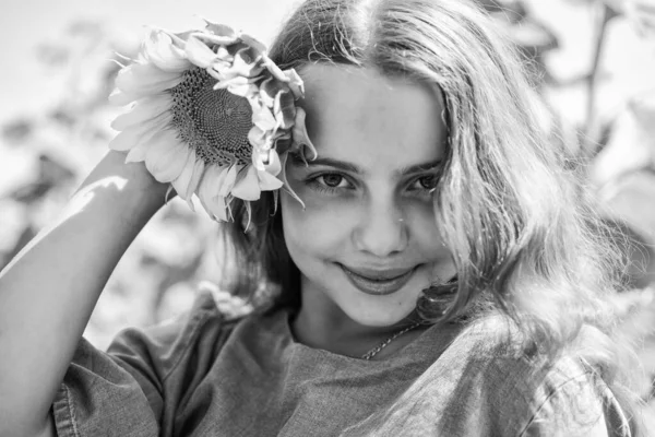 Mooi gezicht klein meisje spelen zonnebloemen natuur achtergrond, schoonheid concept — Stockfoto
