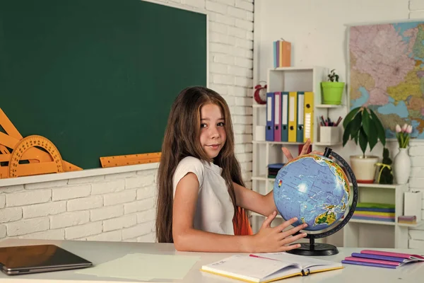 Ребенок в классной школе с доской и географическим глобусом, образование — стоковое фото