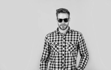 Gözlüklü, bakımlı saçlı ve sakallı bir erkek.