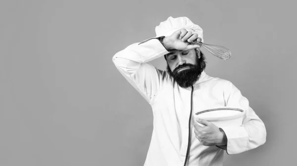 Hipster brutal fatigué dans tablier fini repas de cuisine. C'est l'heure de manger. cuisson difficile. concept de ménage. homme barbu mature porter un chapeau de chef. cuisinier masculin prêt pour la préparation des aliments. épuisé et fatigué — Photo