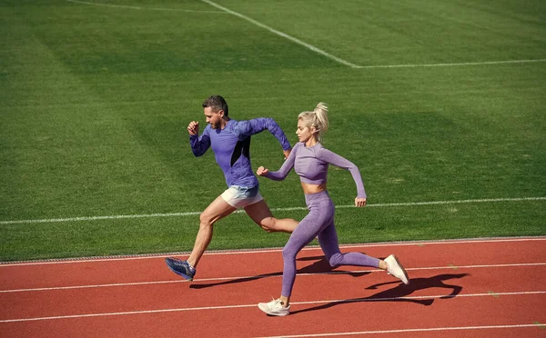 Mujer atlética y hombre de velocistas corren en pista de atletismo en el estadio, resistencia — Foto de Stock