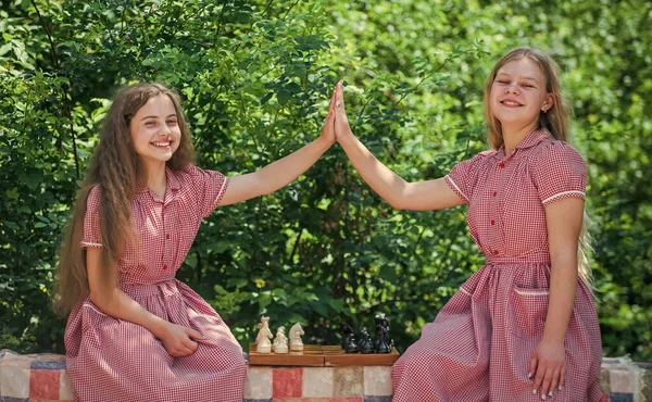 Dwie nastolatki grające w szachy. rozwój dzieciństwa. przyjaźń i siostrzane więzi. — Zdjęcie stockowe