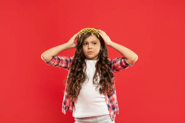 Niño preocupado con el pelo rizado en la corona de princesa sobre fondo rojo, ganador — Foto de Stock