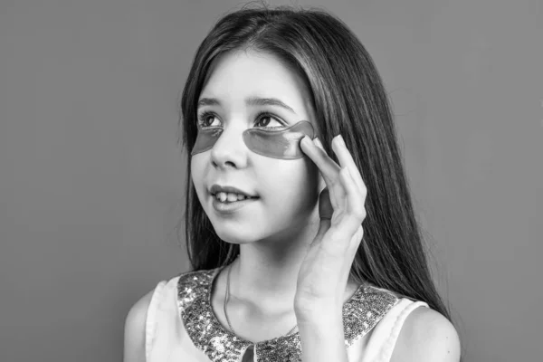 Φροντίδα του δέρματος. χαριτωμένο έφηβος κορίτσι με καστανά μαλλιά χρήση patch μάτι. Κορεάτικα καλλυντικά. Χαρούμενο παιδί με μάσκα προσώπου. έννοια της φυσικής ομορφιάς. Χαρούμενη παιδική ηλικία. δροσιστικό παιδί με επιθέματα βιταμίνης κολλαγόνου — Φωτογραφία Αρχείου