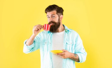 Kafkasyalı, kahve içen, elinde fincan altlığı, sarı arka plan, kafein...