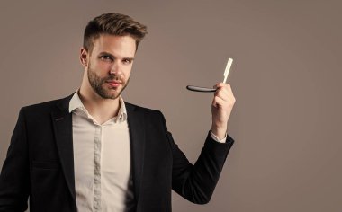 İyi bakımlı bir saç stili. Erkek güzellik ve moda. Sakallı adam için resmi ofis kostümü. Tıraş bıçağı olan traşsız yakışıklı bir adam. Kuaför konsepti. Genç ve kendinden emin berber. Yüz bakımı