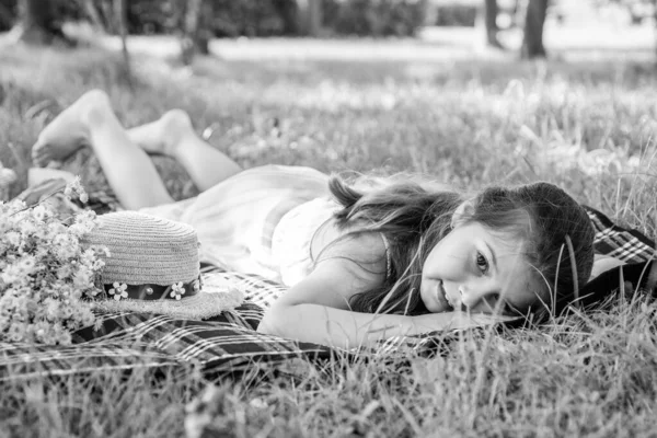 Чарівна маленька дівчинка розслабляється на ковдрі на відкритому повітрі, концепція літніх канікул — стокове фото