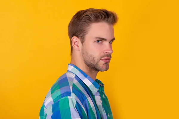 Bonito unshaven cara com cara séria metade virar fundo amarelo, retrato — Fotografia de Stock