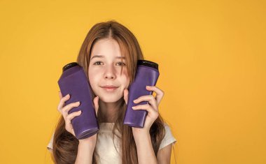 Sevimli kız çocuğunun moda bir saç stili var ve şişede losyon kullan, güzellik kozmetiği.