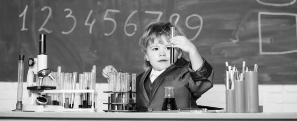 Dzieciak w fartuchu uczy się chemii Mały dzieciak uczy się chemii w szkolnym laboratorium. Mały chłopiec w apteczce. laboratorium chemiczne. Wracać do szkoły. Eksperymentuje z chemikaliami. Poprawa nowoczesnej medycyny — Zdjęcie stockowe