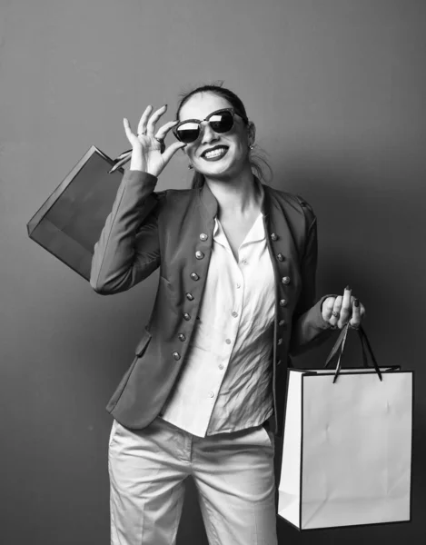 Divat lány napszemüvegben tartsa papírzacskók, vásárlás — Stock Fotó