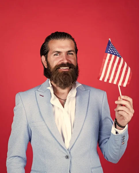 Concepto patriotismo. brutal hombre guapo con bigote. trabajar y viajar a Estados Unidos. Día de la independencia. masculinidad y carisma. código de vestimenta de fiesta formal. barbudo político sostiene bandera americana — Foto de Stock