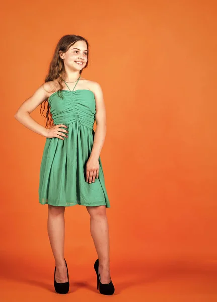 Söt unge i klänning på orange bakgrund, trend — Stockfoto